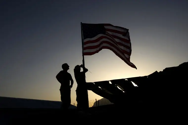 U.S. Marines raise a flag over their base in the Farah Province of southern Afghanistan on Oct. 6, 2009.