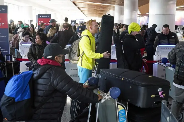 People wait in line to drop off their luggage at Los Angeles International Airport