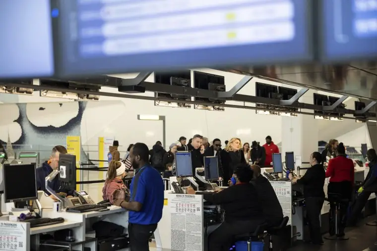 Passengers wait in line to check in for their flights at Southwest Airlines service desk