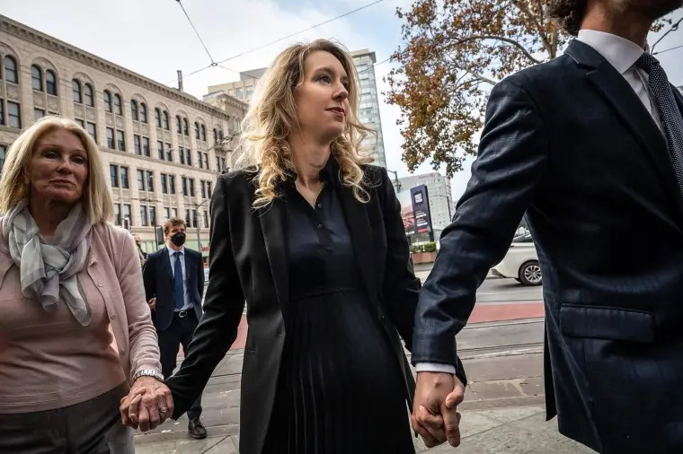 Elizabeth Holmes, founder and former CEO of blood testing and life sciences company Theranos, walks with her mother Noel Holmes and partner Billy Evans into the federal courthouse for her sentencing hearing on November 18, 2022 in San Jose, Calif.