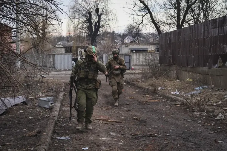 Ukrainian soldiers walk along a street in the area of the heaviest battles with the Russian invaders in Bakhmut, Donetsk region, Ukraine, Wednesday, March 15, 2023. 