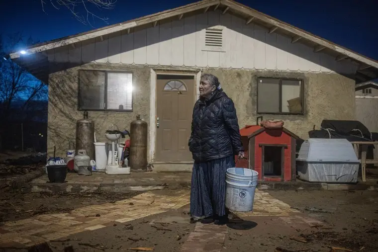 Marilyn Help-Hood,66, holds a bucket to pour her dirty water into on March 13, 2023.