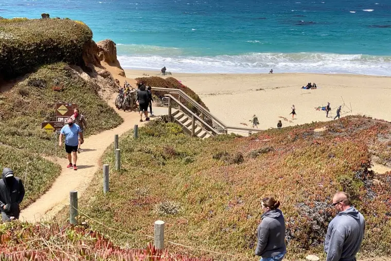 Tourists walk to the beach south of Monterey, Calif., on Aug. 1, 2020.