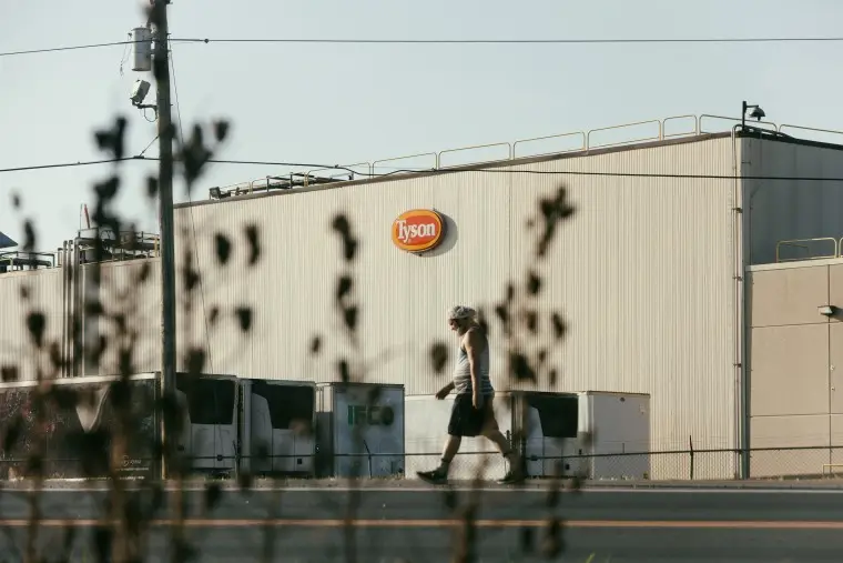 A worker walks along the highway past the Tyson poultry plant in Noel, Mo.