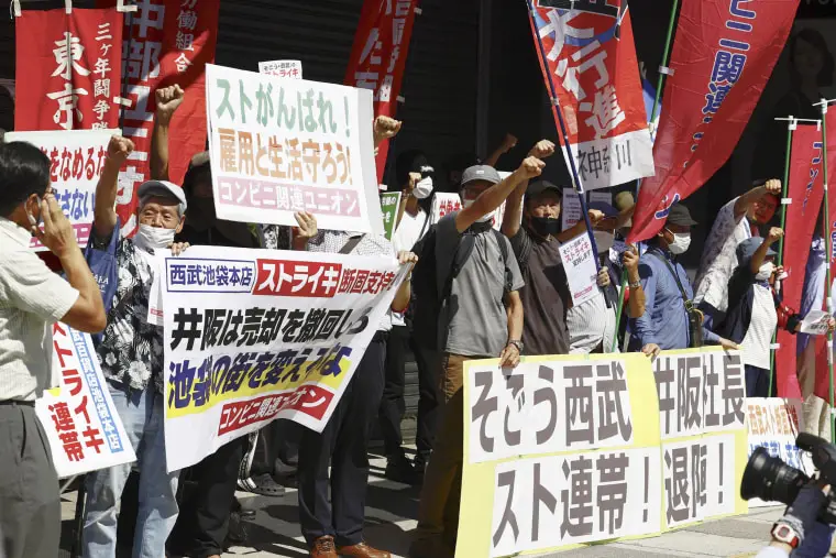 Labor union members of Japanese department store operator Sogo & Seibu stage a rare strike at its flagship store in Tokyo over job security concerns, as its parent company plans to sell the chain to a U.S. fund despite the union's opposition. The banners read "Sogo&Seibu, Strike solidarity, "bottom left, and "President Isaka, Resignation!, " bottom right. (Kyodo News via AP)Image: